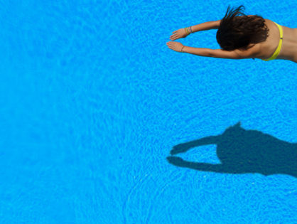 Woman swimming with shadow